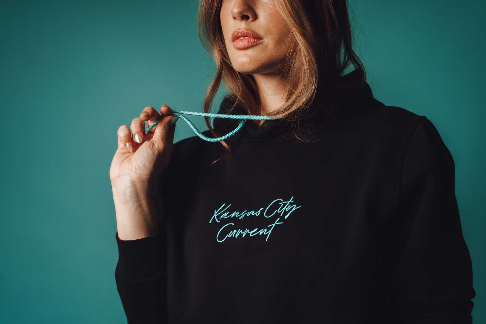 Unisex Black Teal Script Hoodie Zoomed In on Model